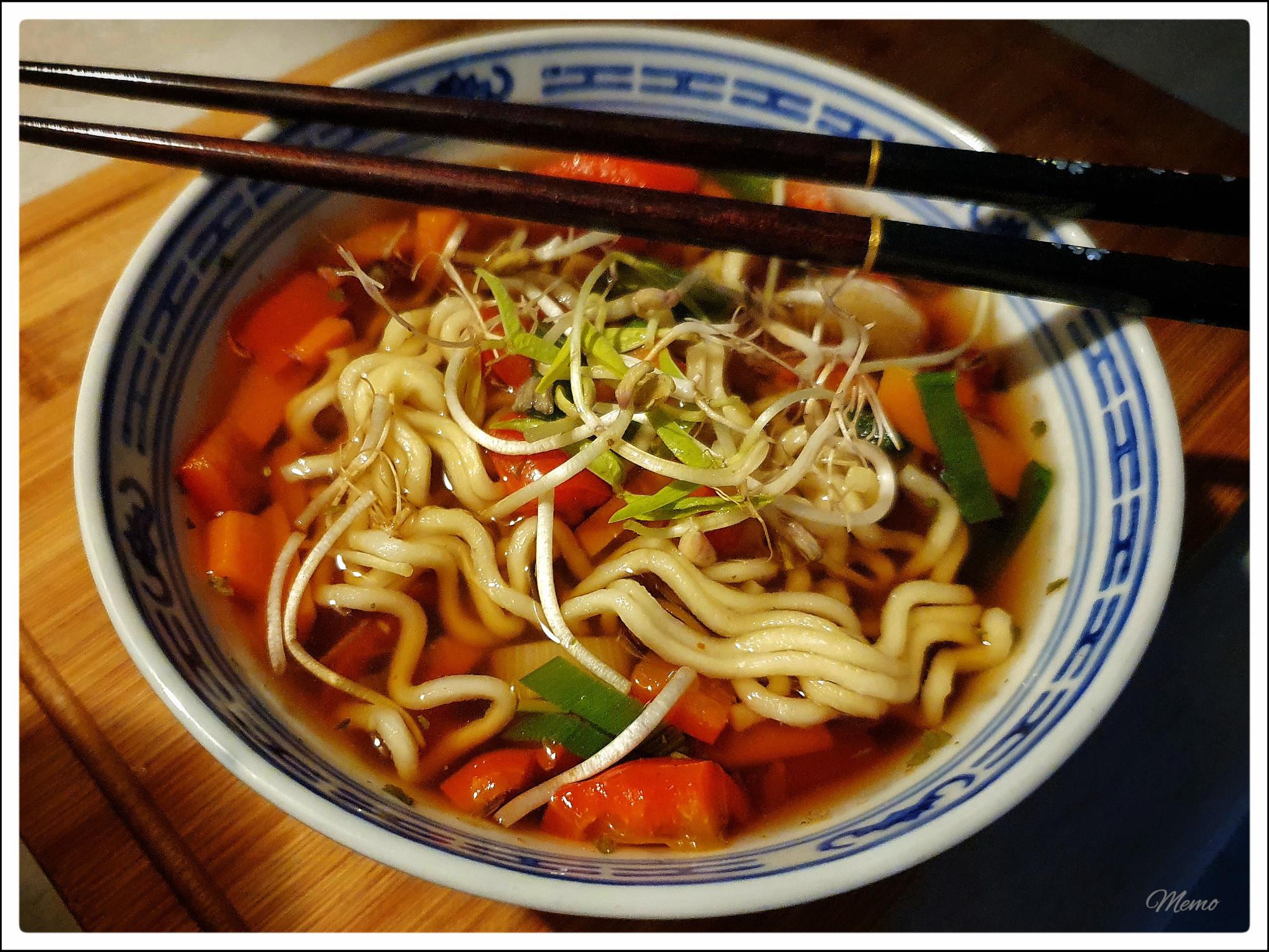 Bildbeschreibung: 
Die fertige Mie-Nudel-Suppe in einer blauweißen Schale. Obenauf liegen Essstäbchen.